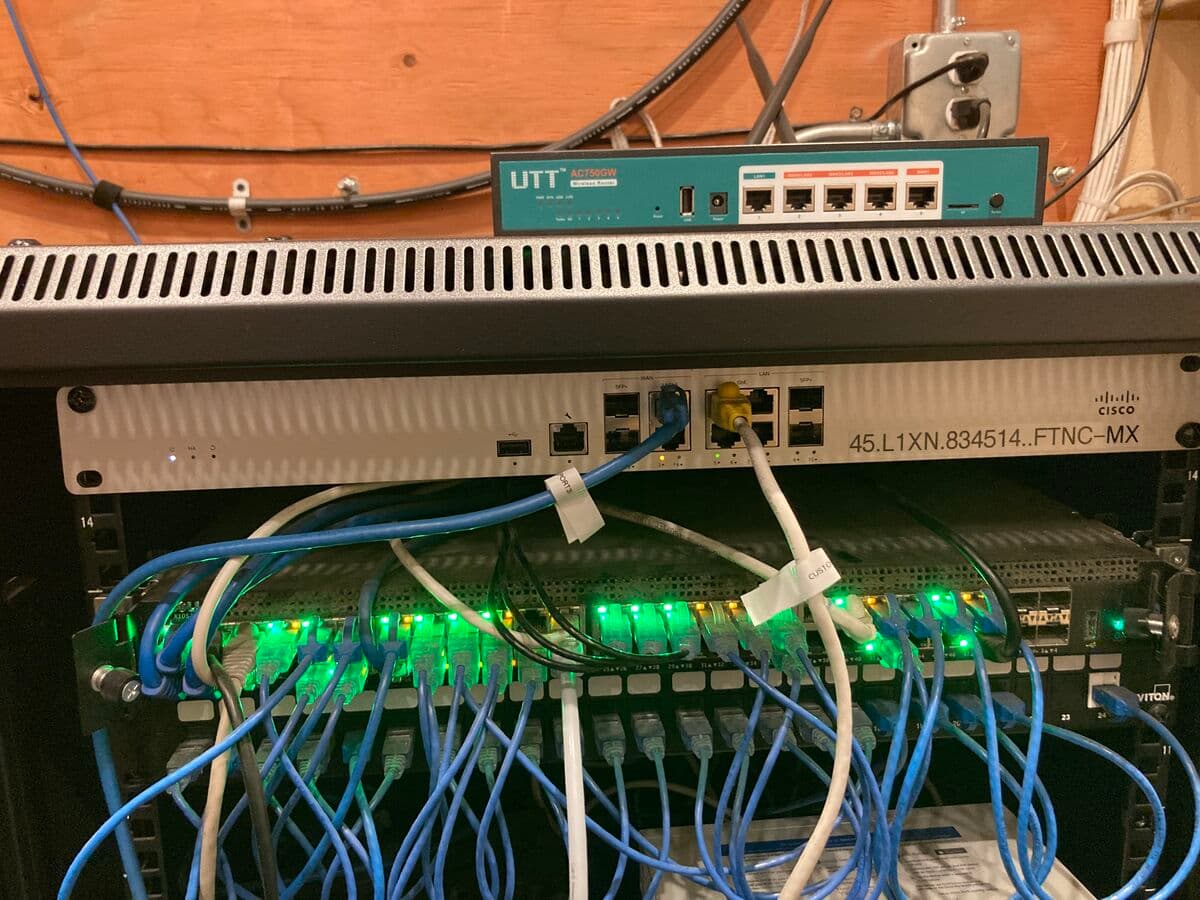 Network rack with Cisco switch and UTT router, blue ethernet cables